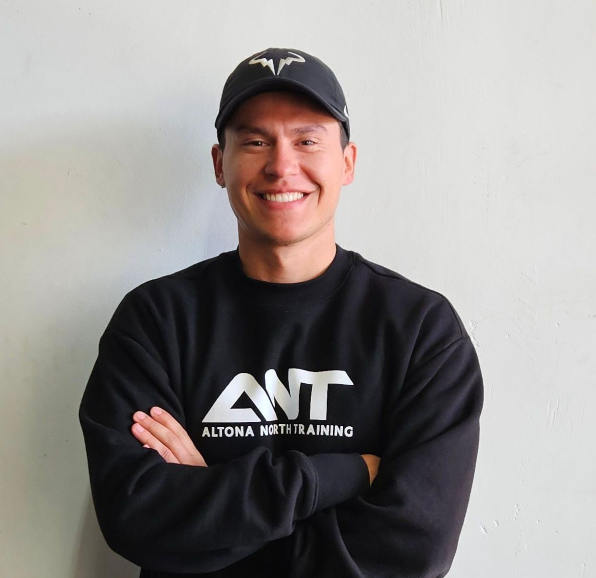 A man wearing a black shirt that says ant on it
