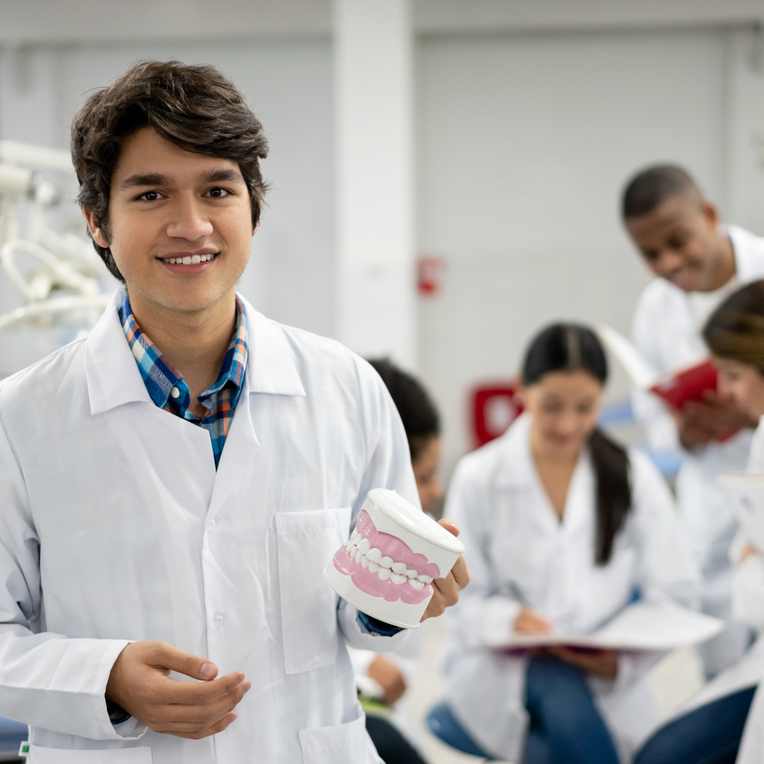 A group of dental professionals taking a selfie together in a dental office. Experience teamwork and camaraderie in your dental practice with Upscale Assessment's comprehensive software for clinical assessment and team collaboration.