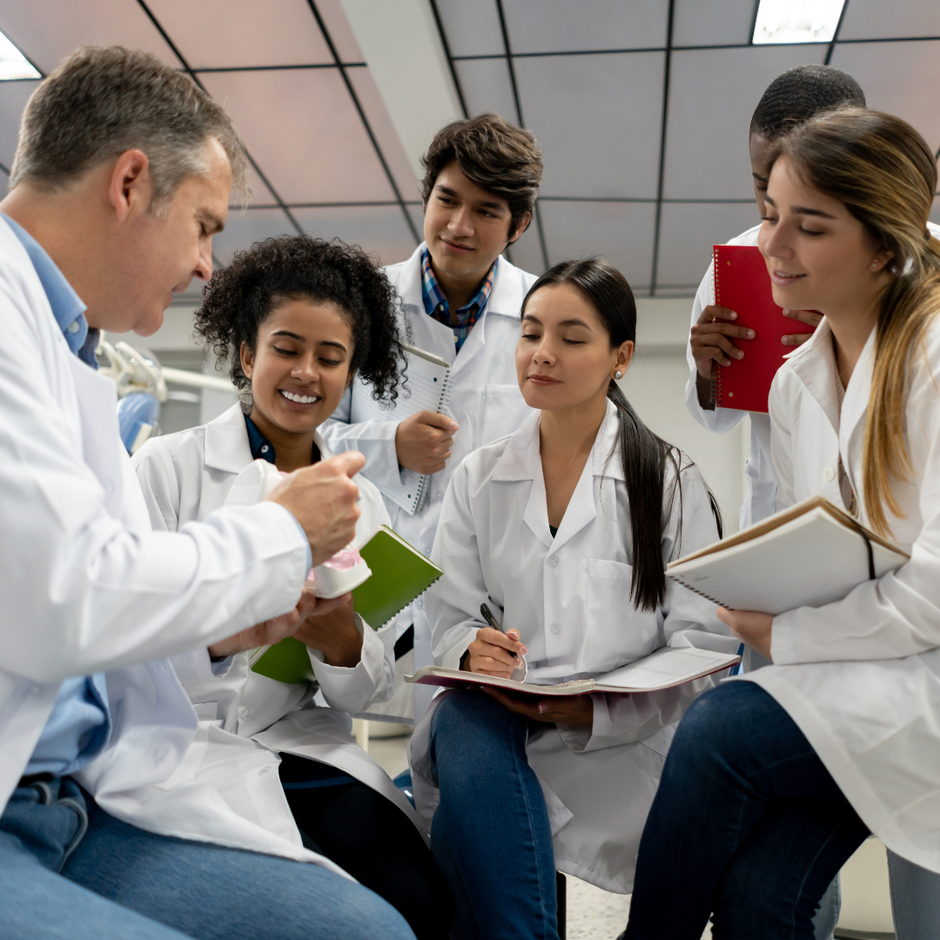 A group of dental students sitting in a circle talking to each other.