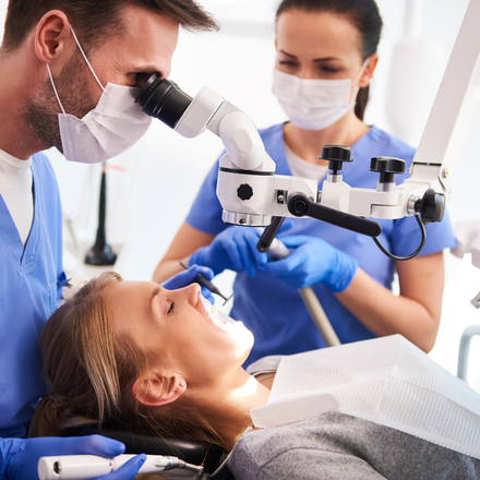 A female dentist providing dental treatment to a patient in a dental office. Experience professional dental care with Upscale Assessment's innovative software for clinical assessment and patient management.