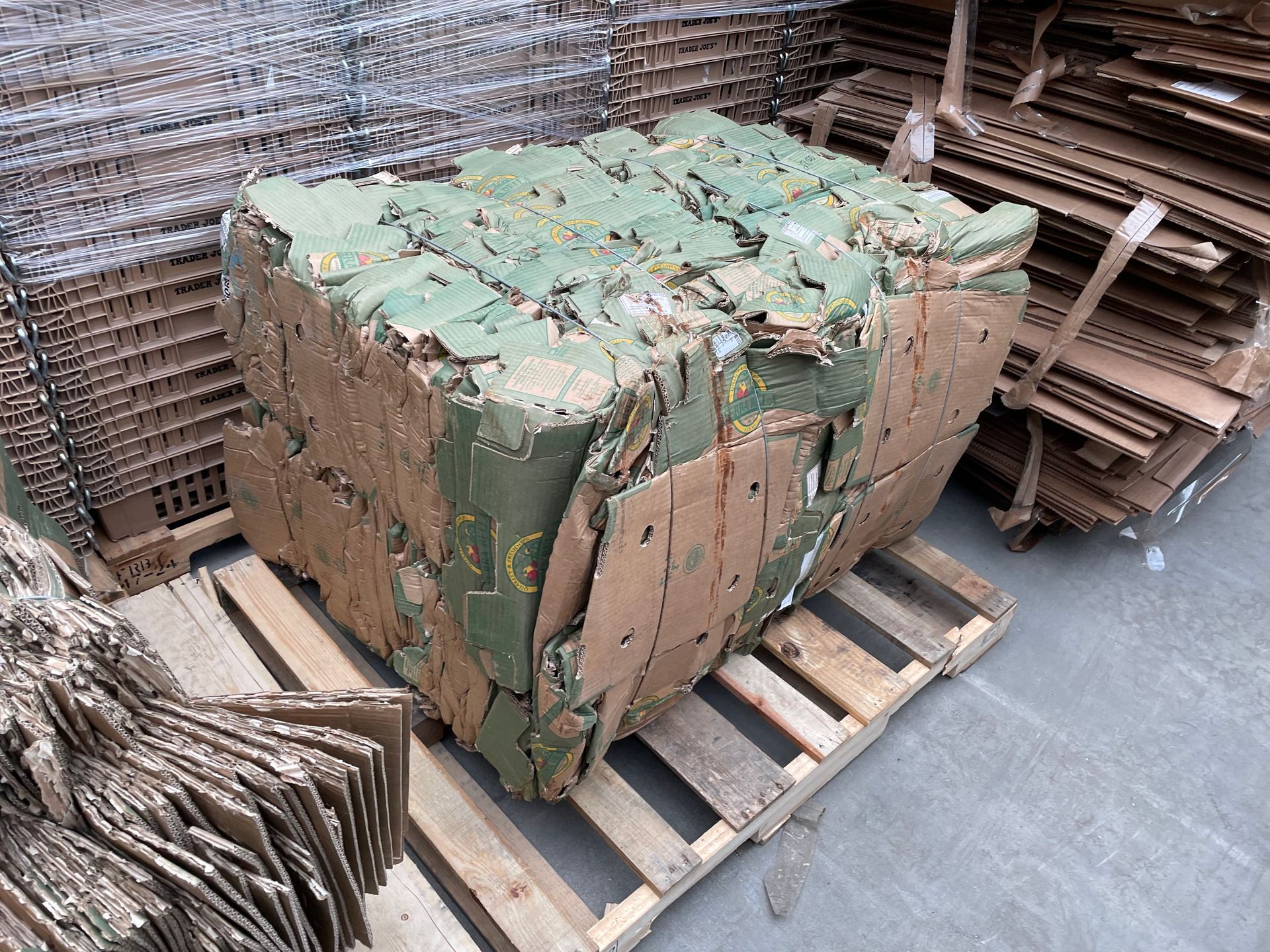 A compressed rectangular bale of cardboard with a pallet underneath.