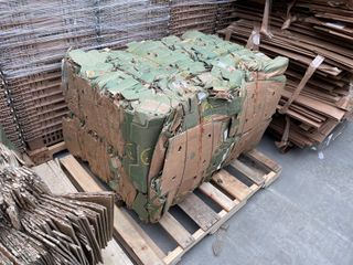 A compressed rectangular bale of cardboard with a pallet underneath.