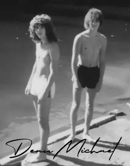 Two people stand side-by-side in swimwear outdoors, with the handwritten text 