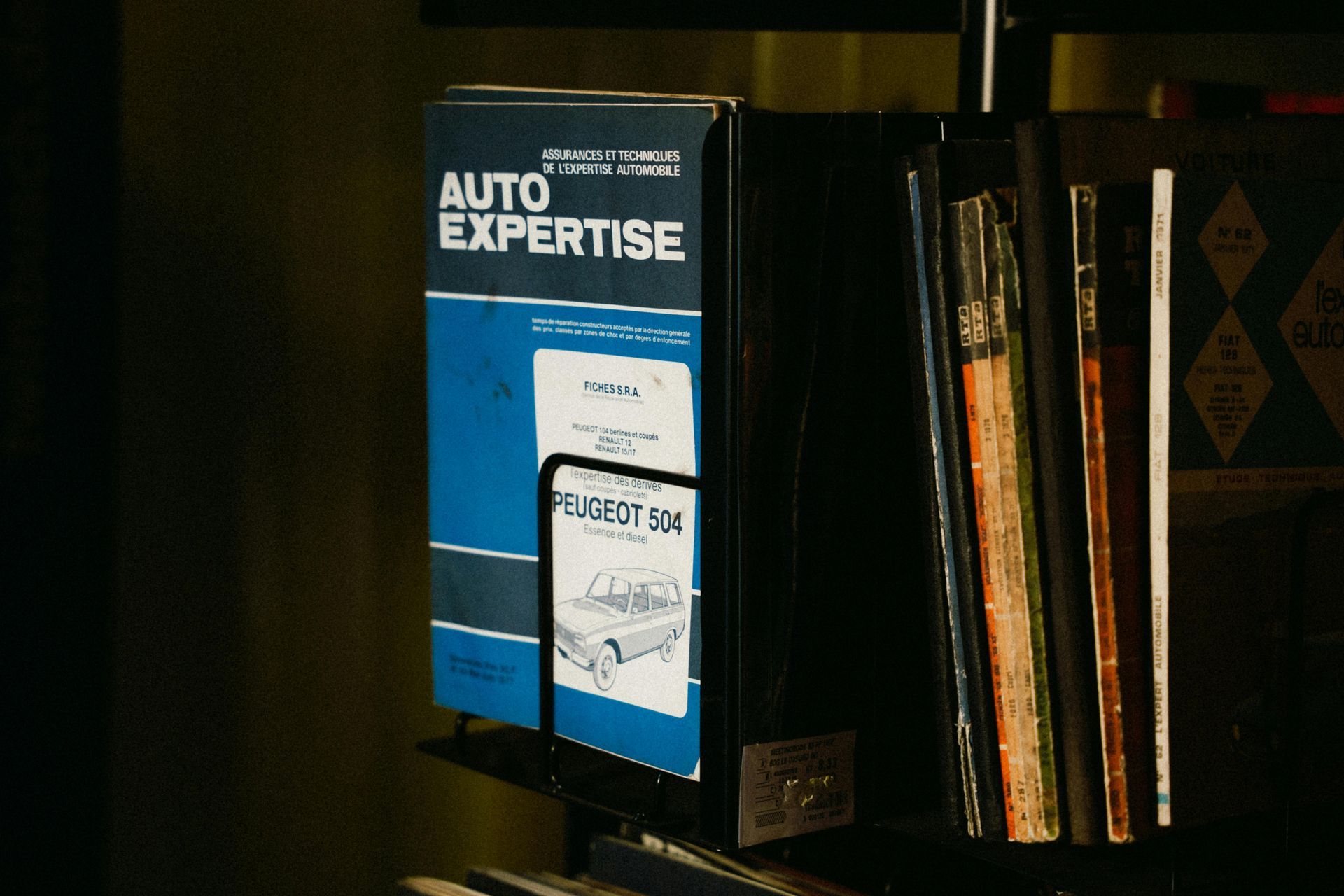 A book titled auto expertise sits on a shelf