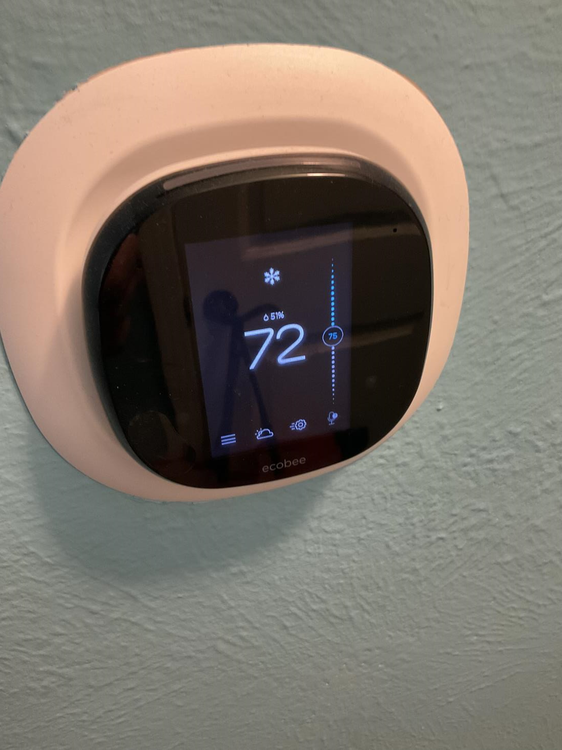 A thermostat on a wall shows 72 degrees