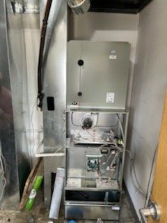 An air conditioner is sitting in a room next to a door.