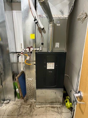 A dirty air conditioner is sitting in a room next to a door.