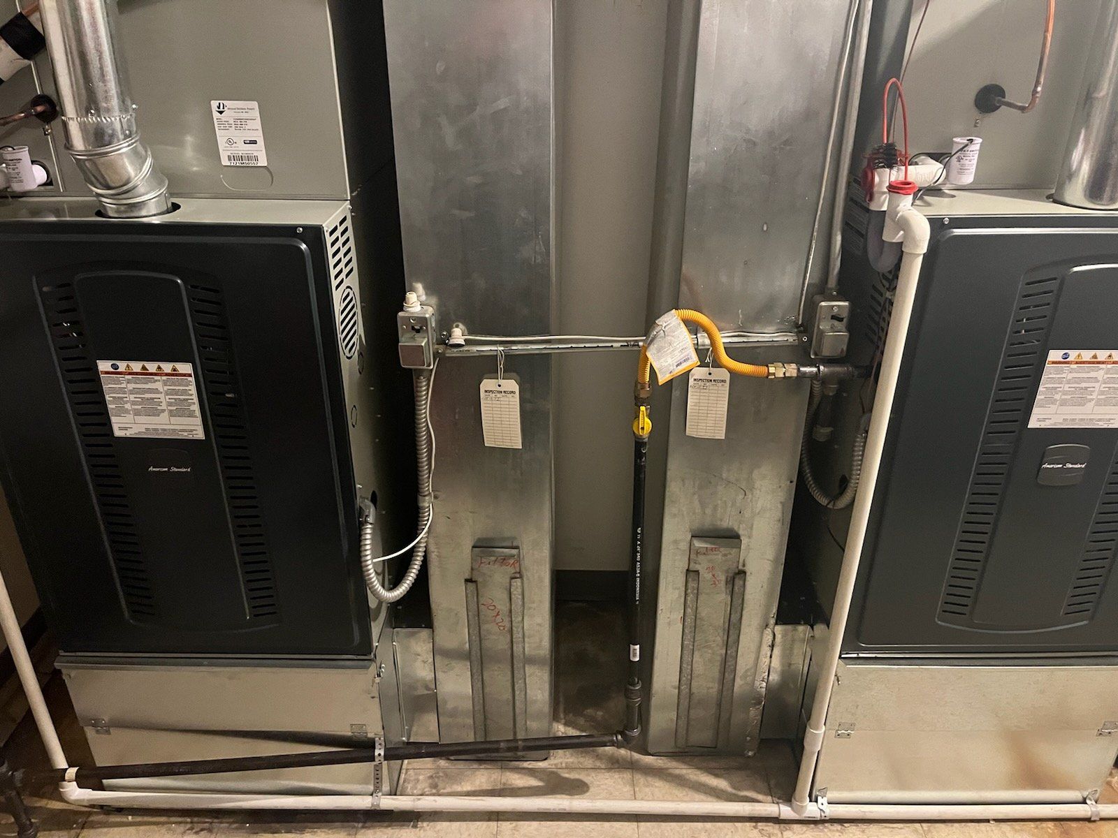 Two air conditioners are sitting next to each other in a room.