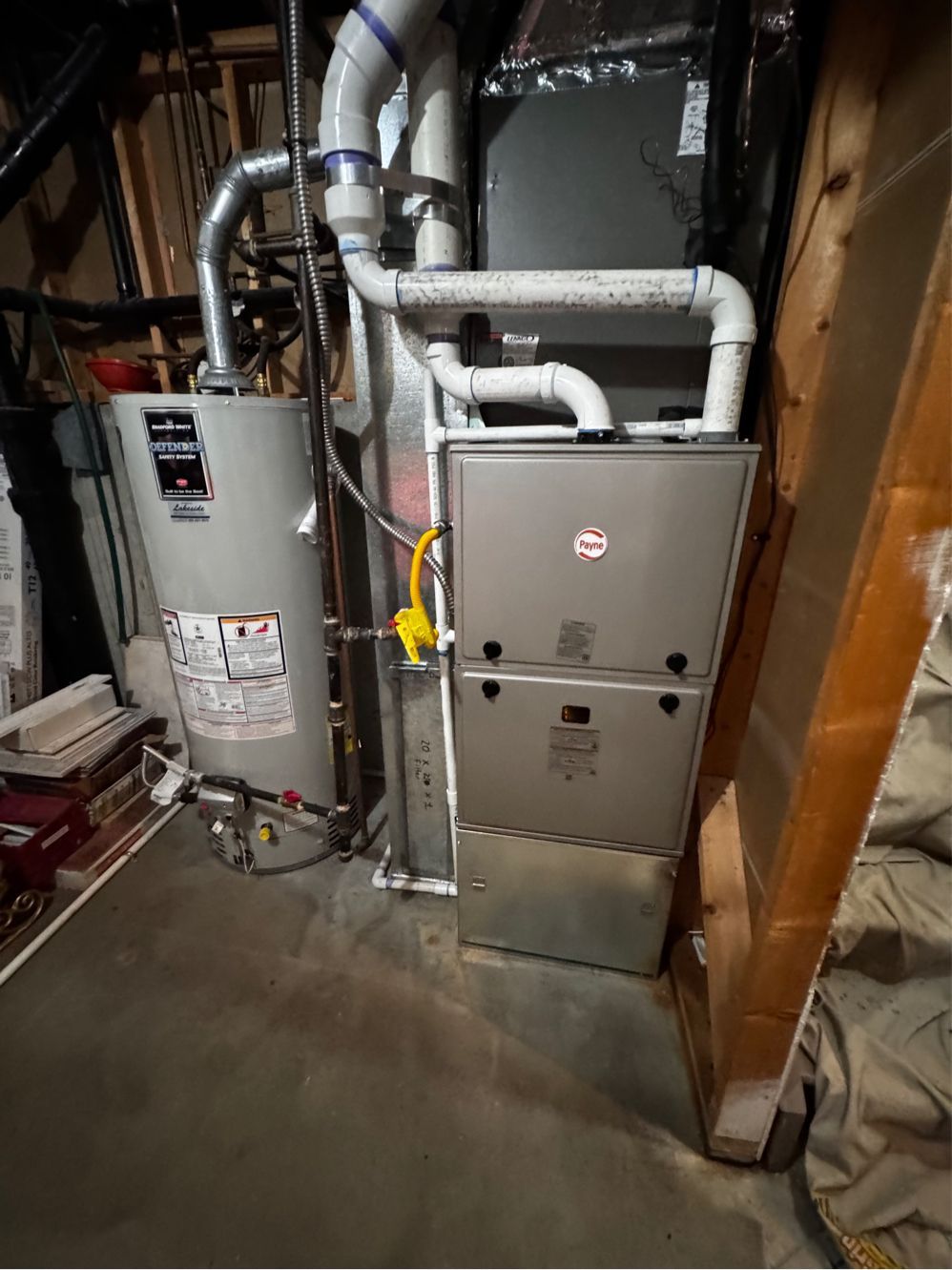 A couple of furnaces sitting next to each other in a garage.