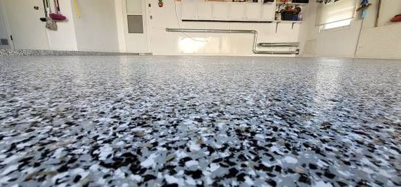 A close up of a gray and black floor in a garage.