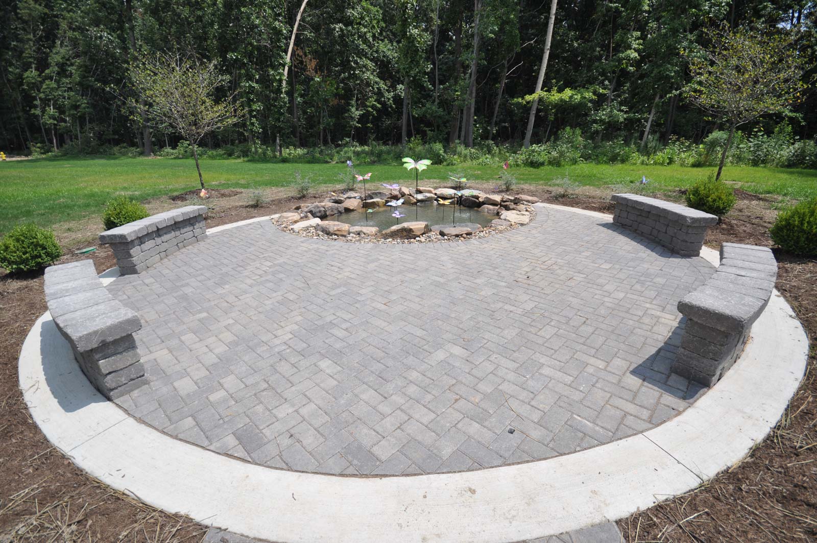 The Commons at Madaline Park benches outside with a small pond