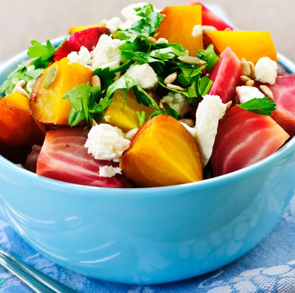 A group of people are sitting on a couch holding hands and smiling.