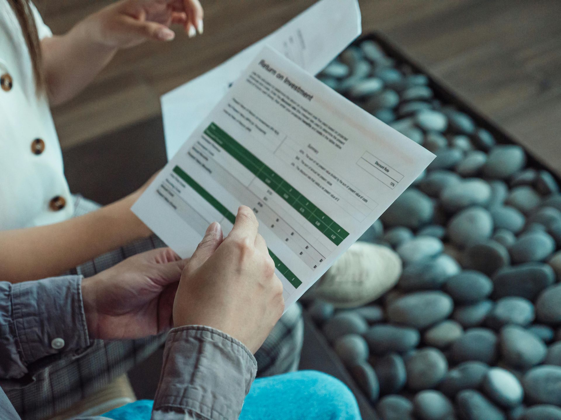 A man and a woman are sitting looking at an investment sheet.