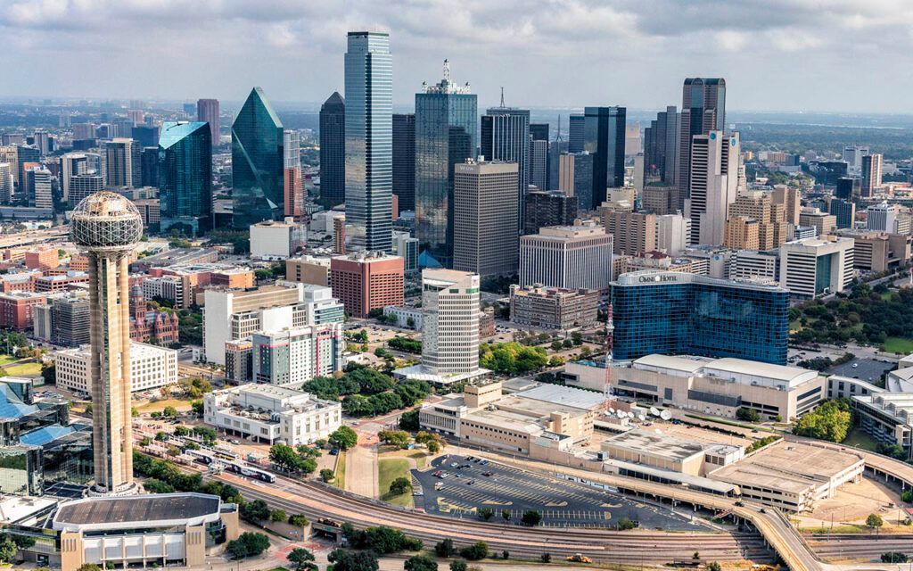 Aerial view of downtown Dallas, Texas, featuring the iconic Reunion Tower, modern skyscrapers