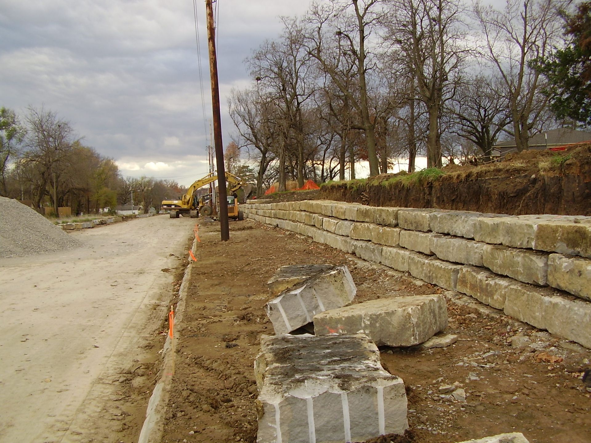 A concrete wall is being built on the side of a road