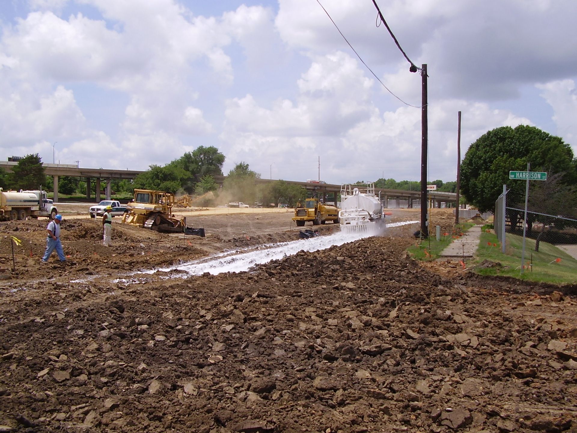 A large pile of dirt is being worked on by construction vehicles