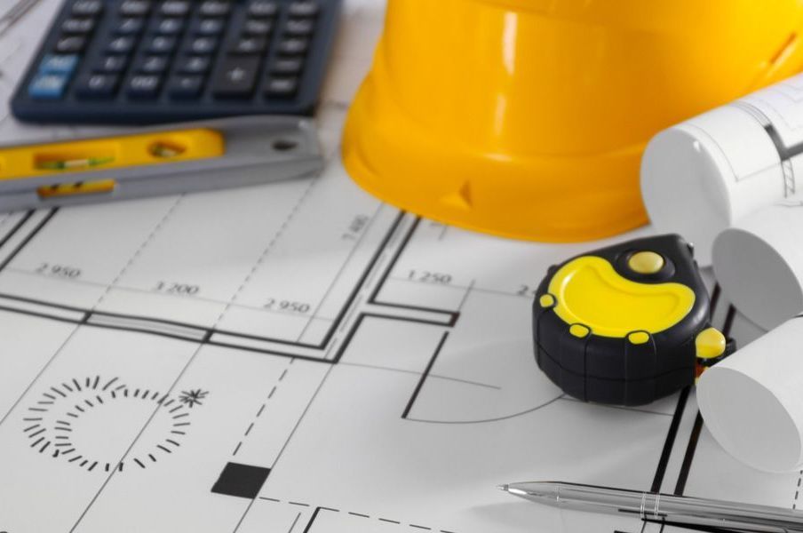 A yellow hard hat sits on top of a blueprint