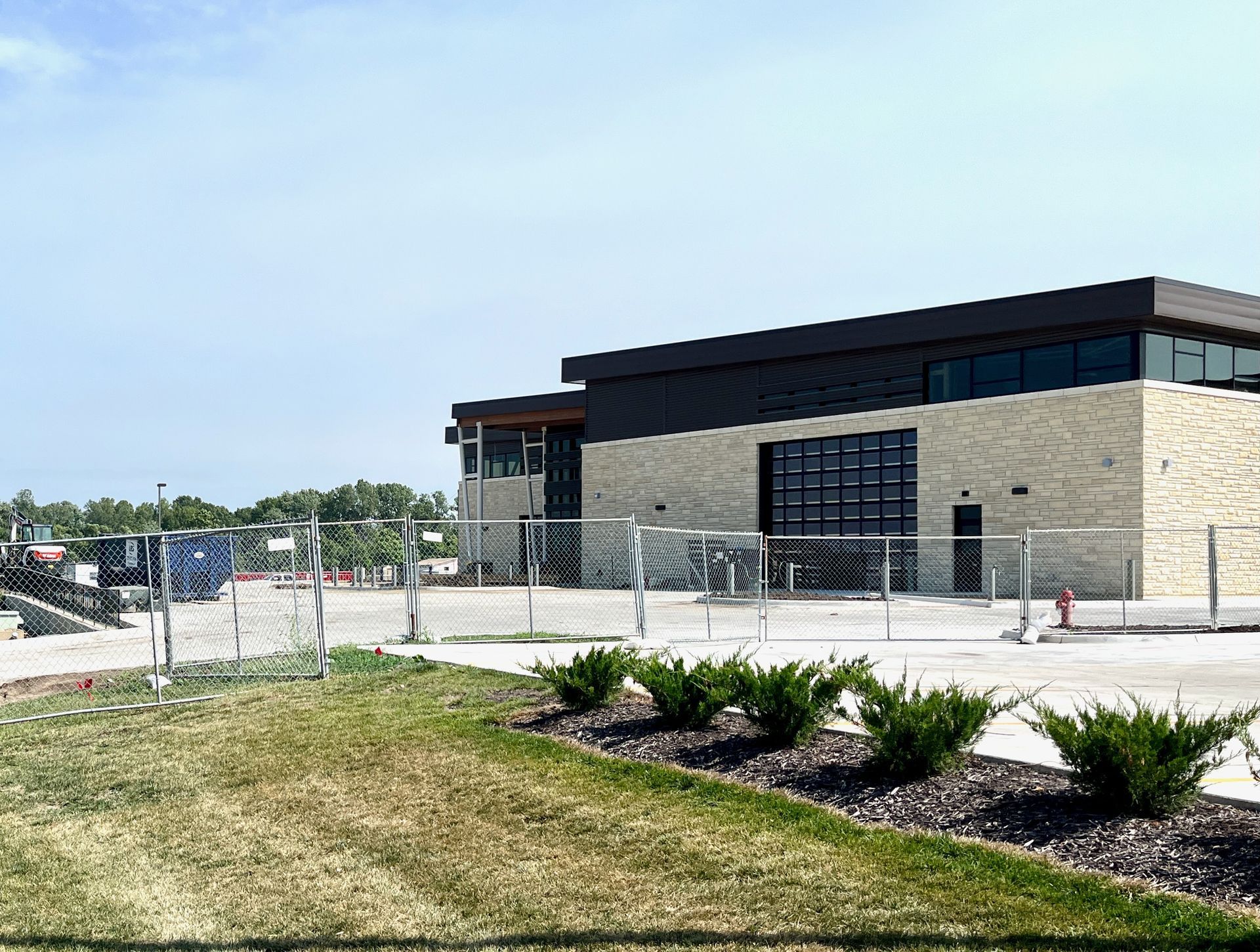 A large building with a lot of windows is surrounded by a fence.