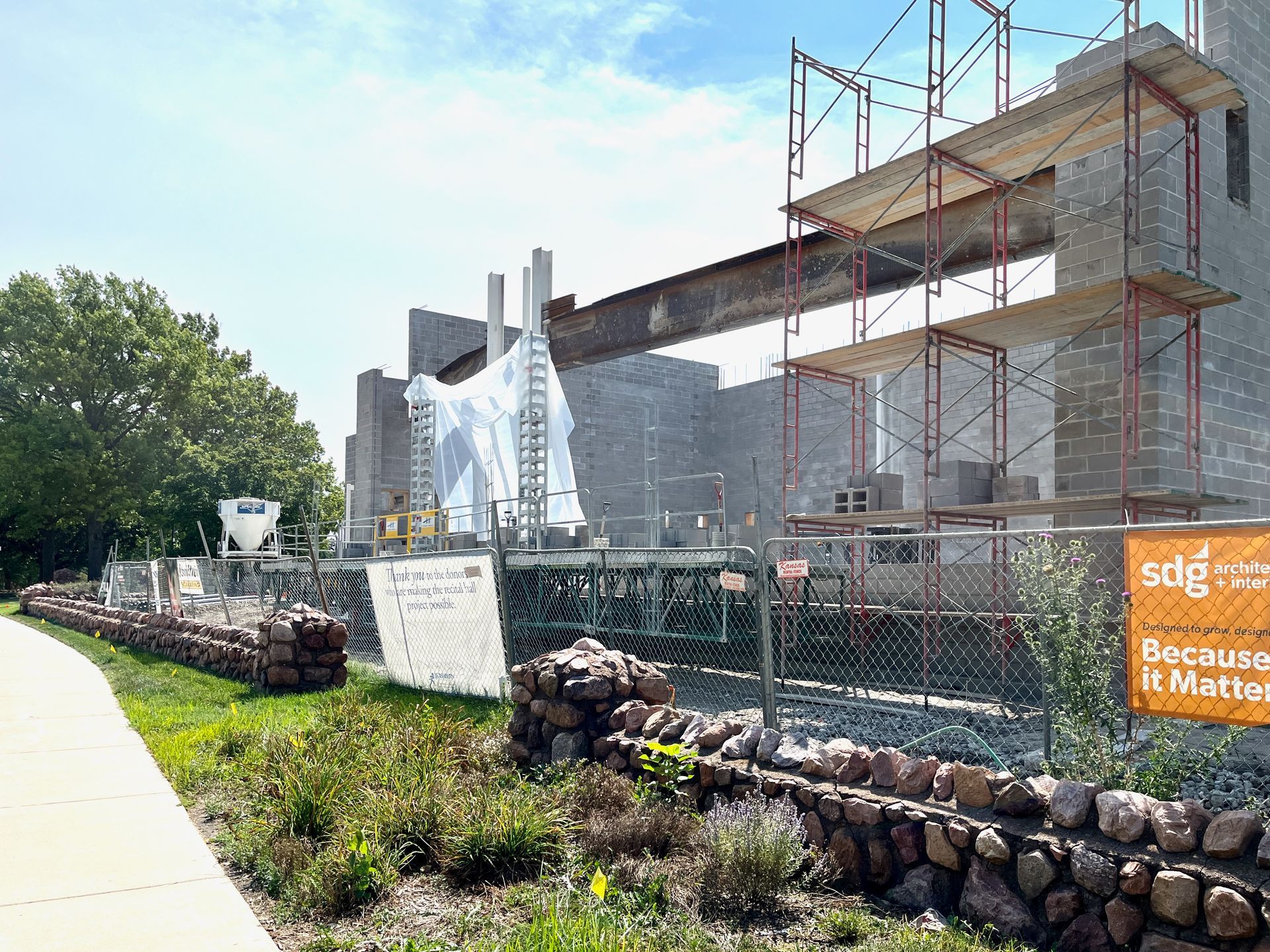 A building under construction with scaffolding and a sign that says sdg on it.