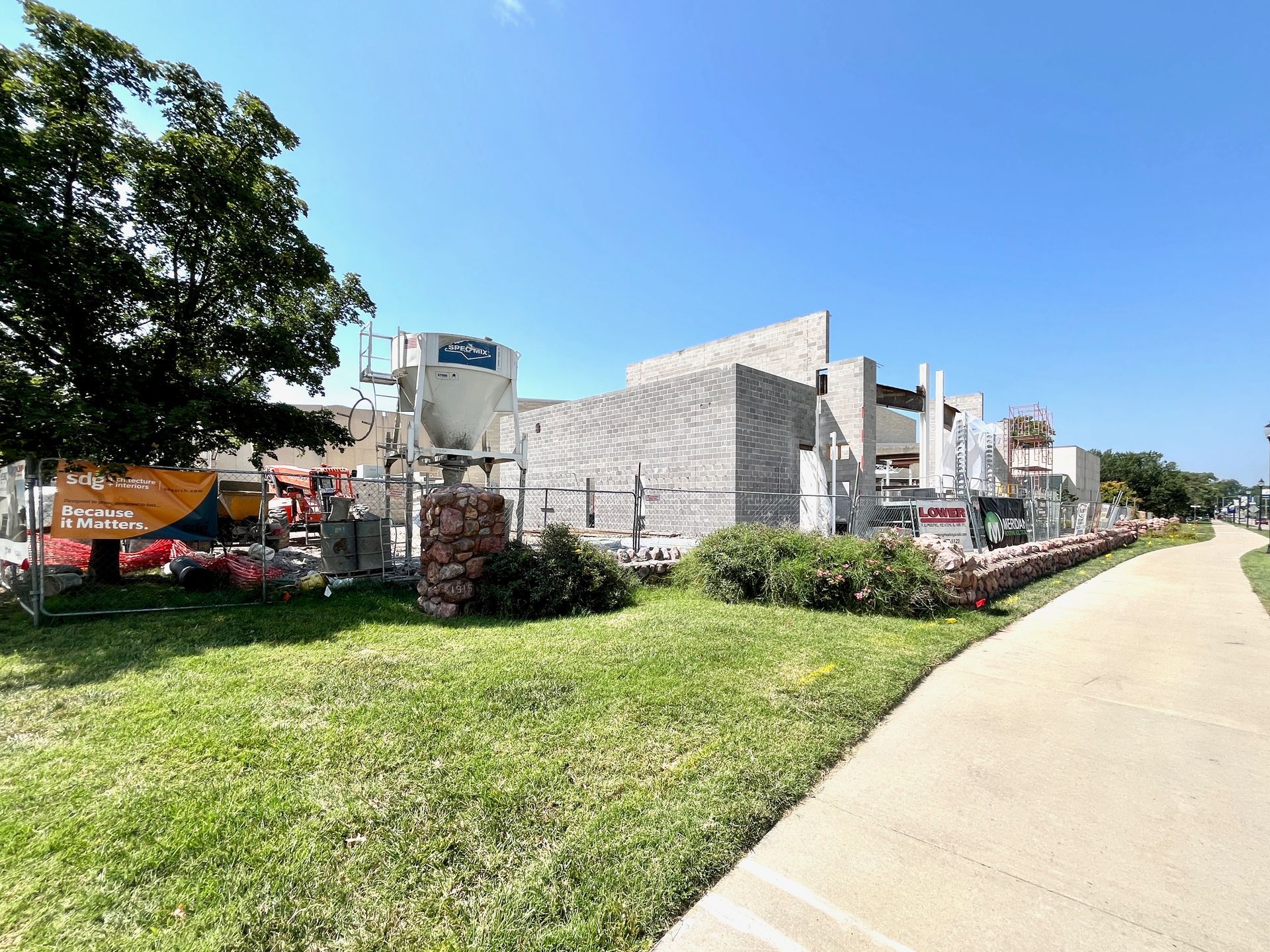 A concrete walkway leading to a building under construction.