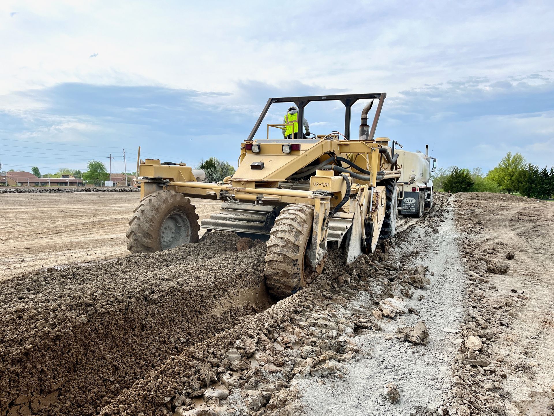 A bulldozer is driving through a muddy field.