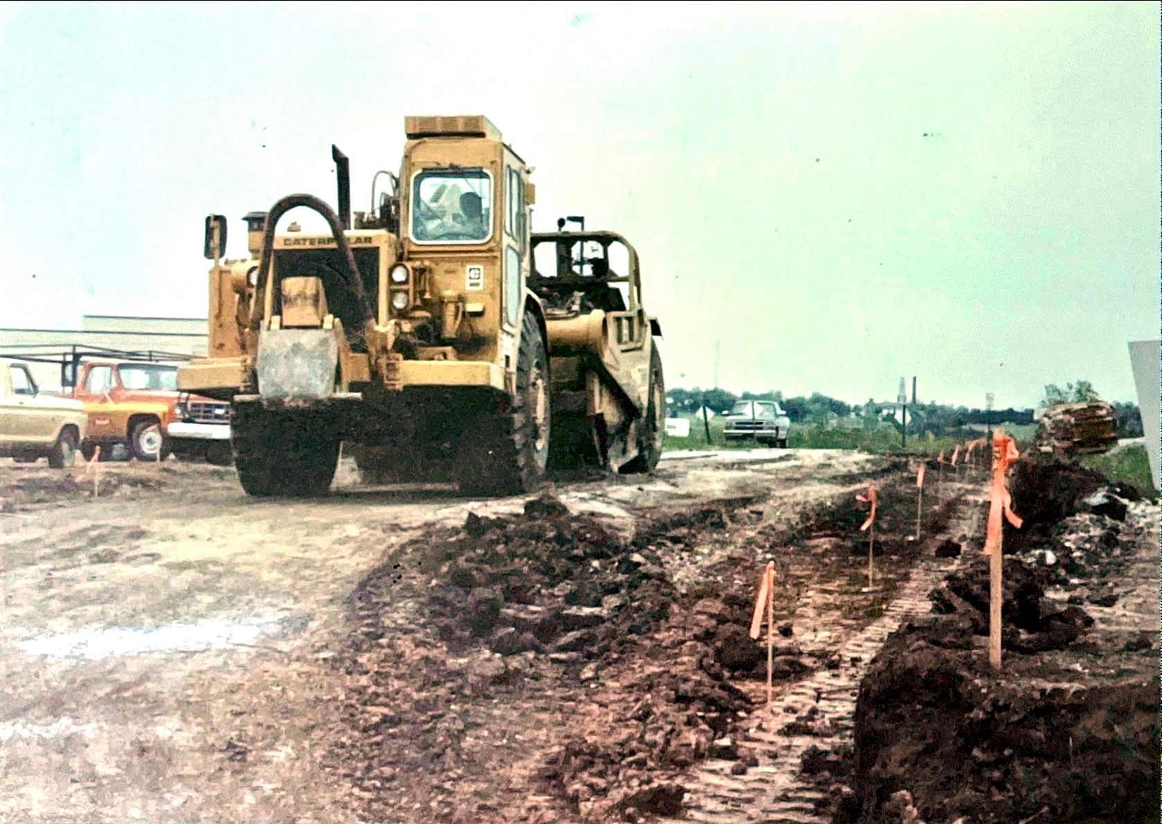 Two bulldozers are working on a dirt road