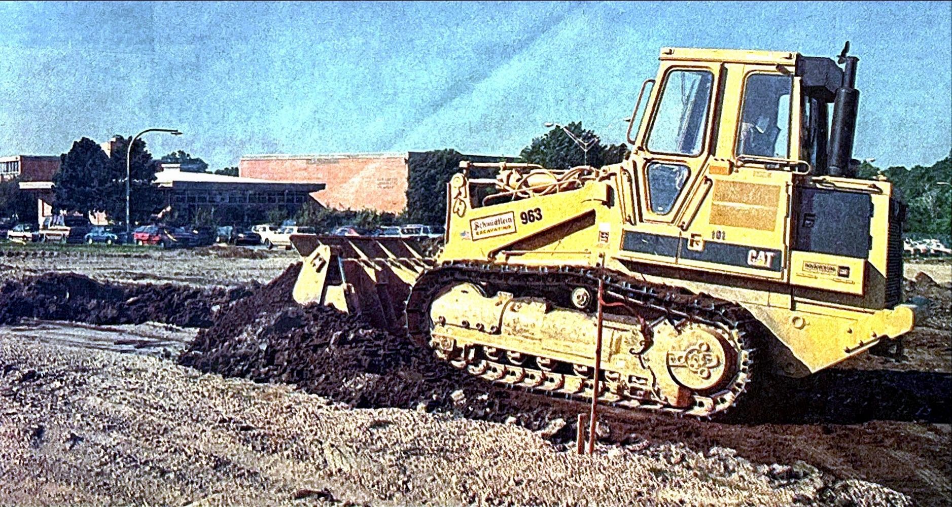 A yellow bulldozer is moving dirt on a construction site