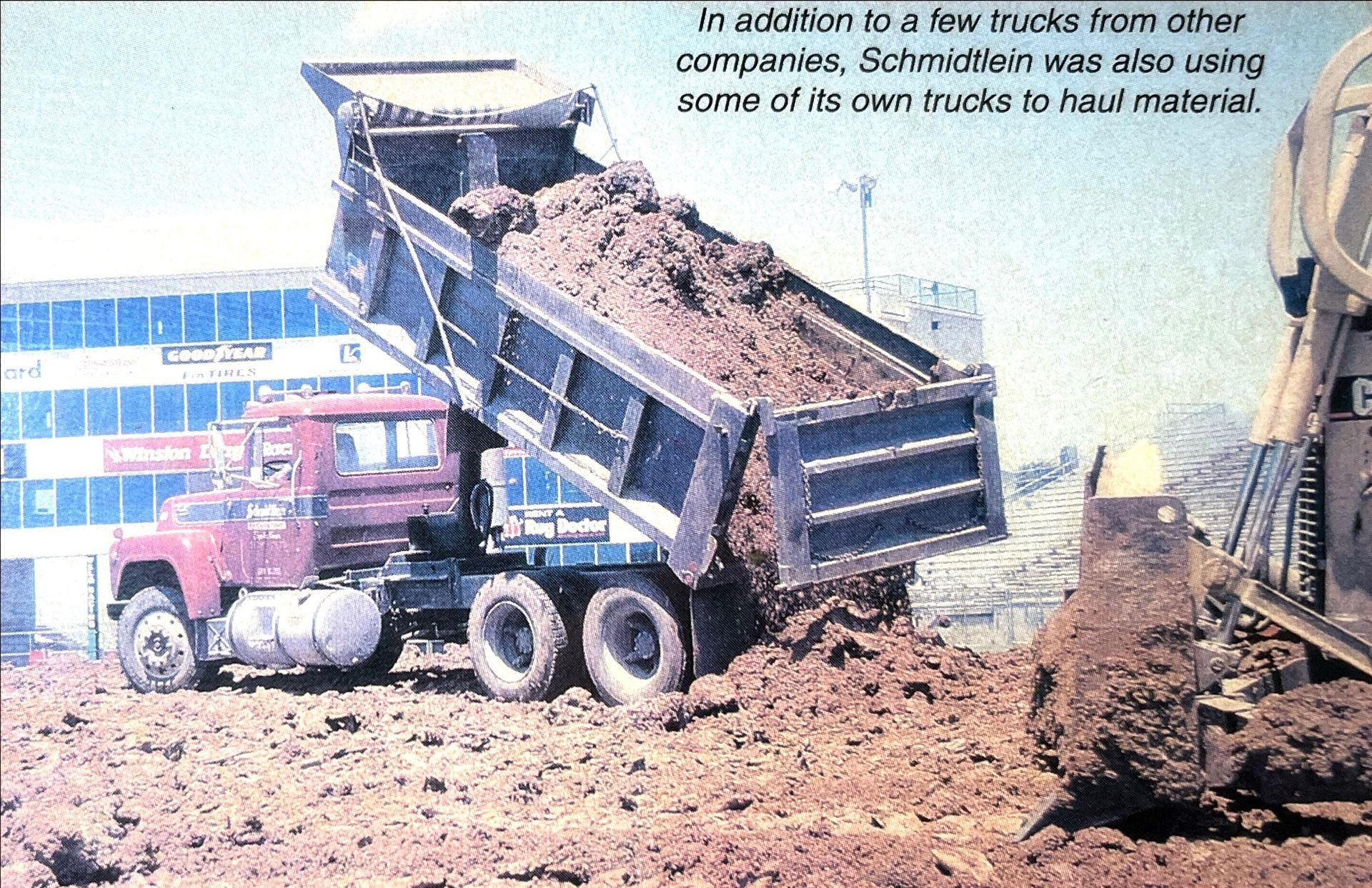 A picture of a dump truck being loaded with dirt