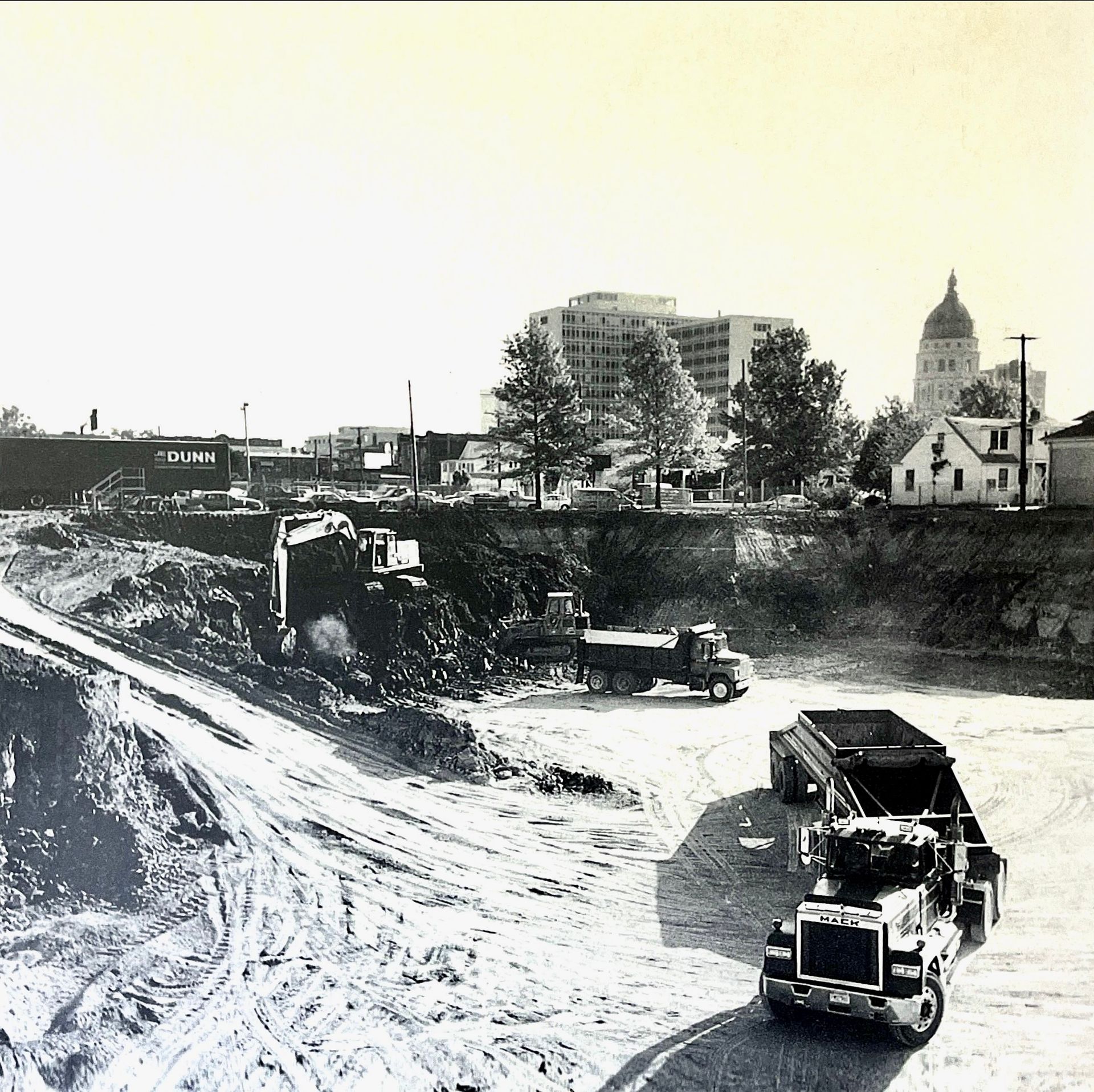 A black and white photo of a construction site with the capitol building in the background