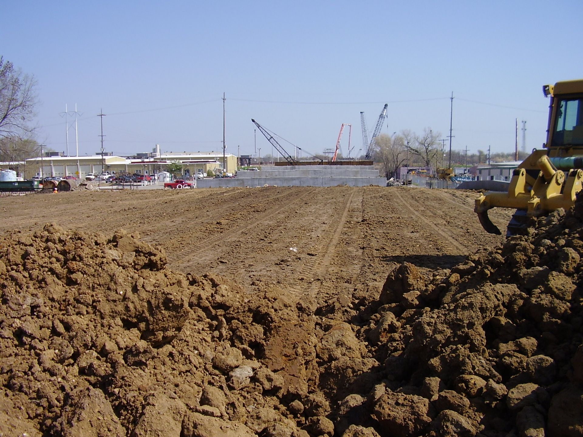 A yellow bulldozer is plowing a dirt field