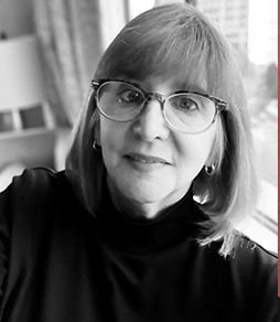 A black and white photo of a woman wearing glasses and a black turtleneck.