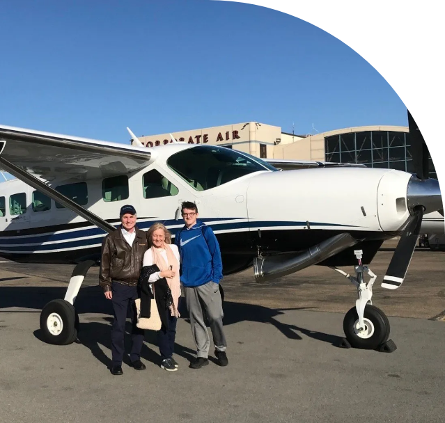 Three people are standing in front of a plane that says aerogate air