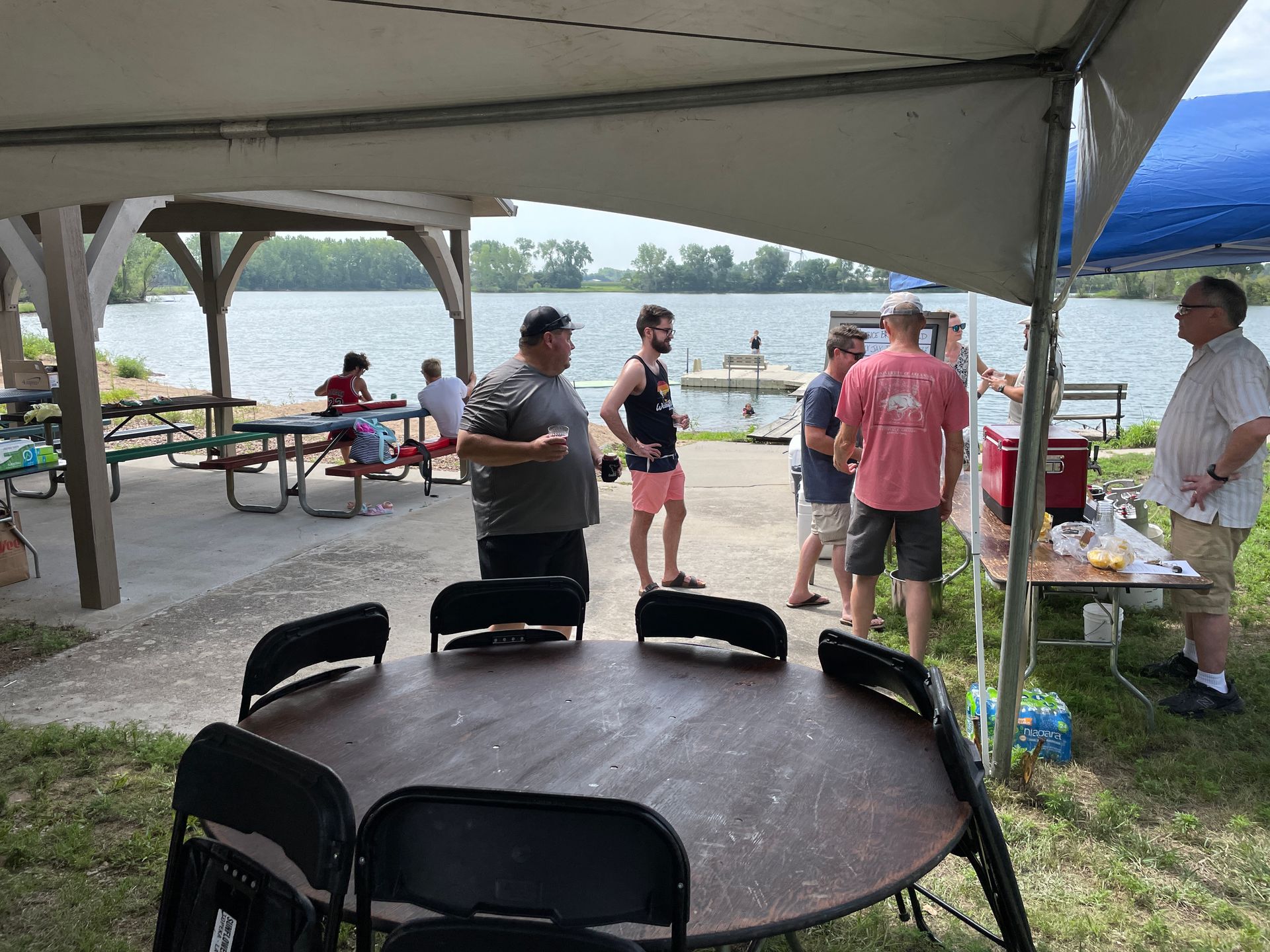 Men stand around a patio and talk at the ICL Family Picnic.