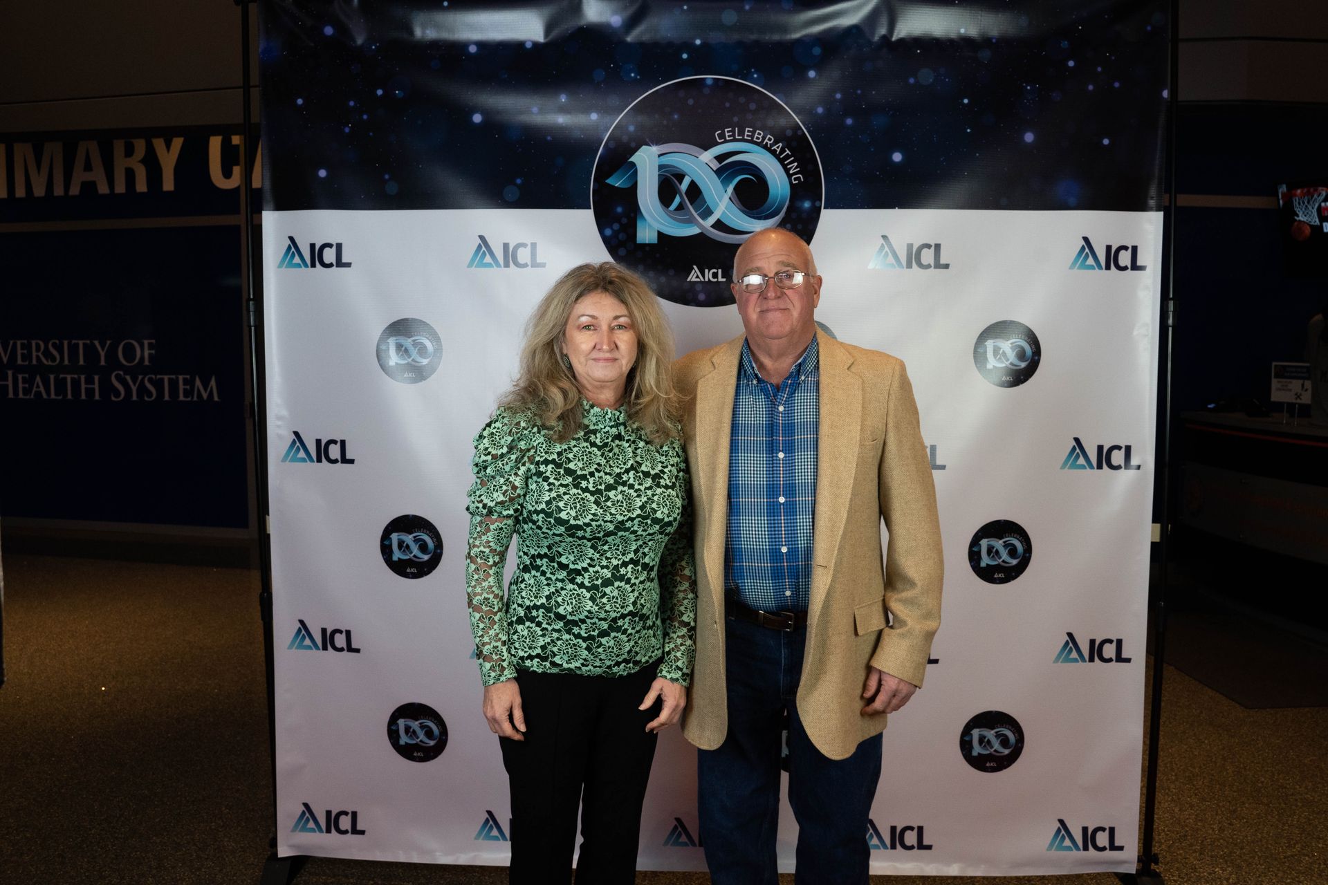 two employees standing at an ICL 100 year aniversary party