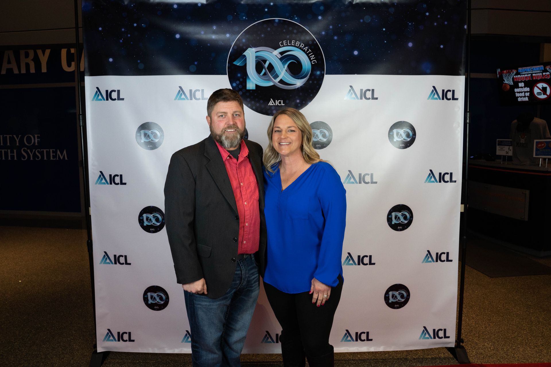 two employees standing at an ICL 100 year aniversary party