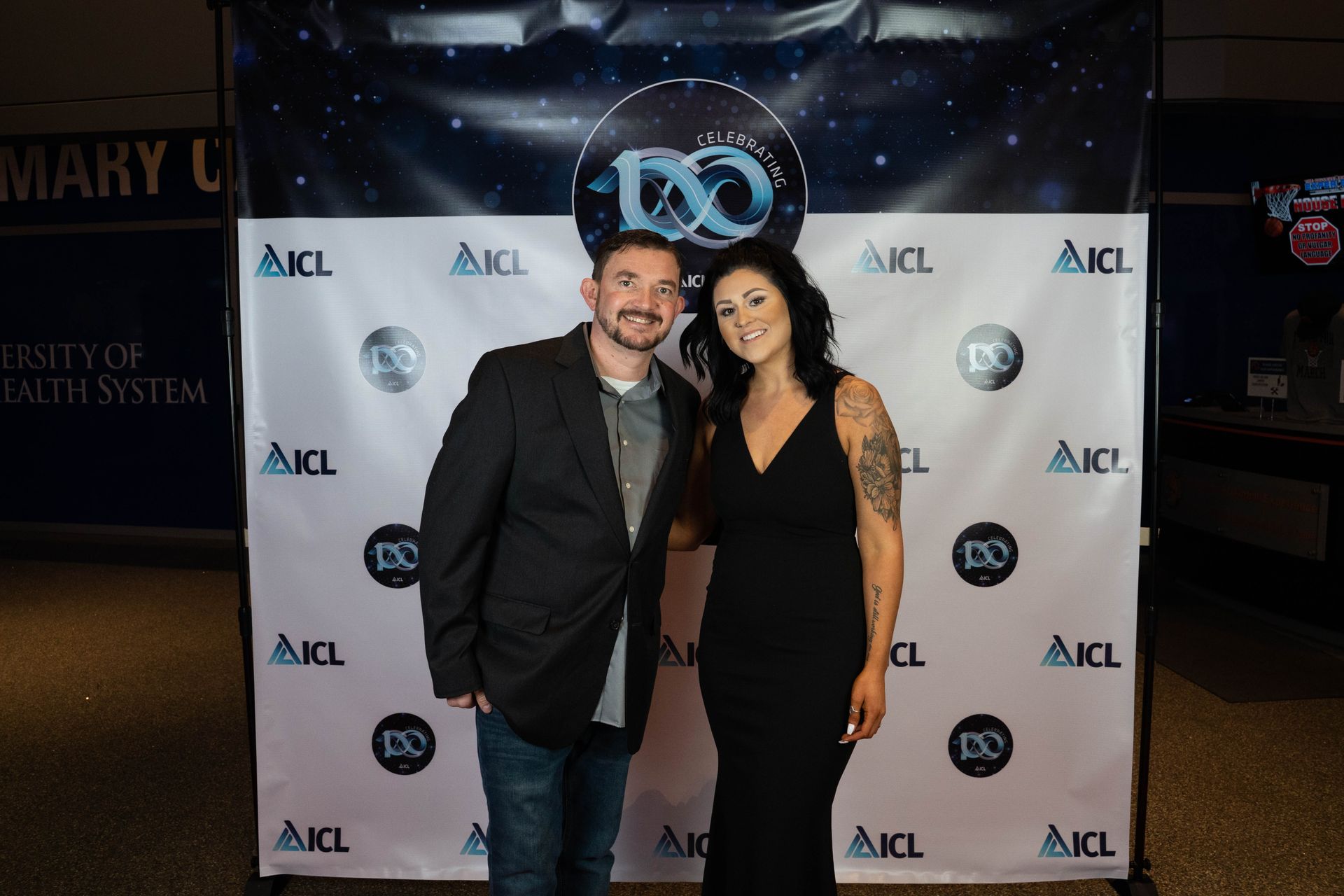two employees standing at an ICL 100 year aniversary party
