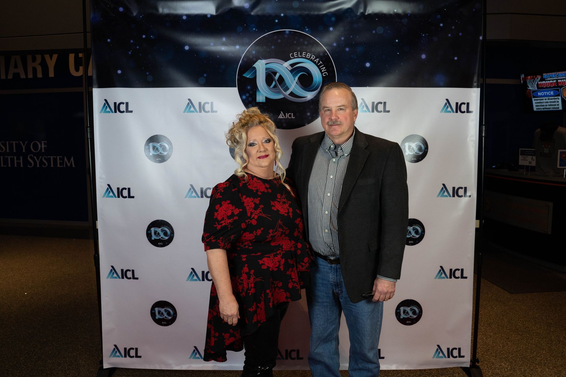 two employees standing at an ICL 100 year aniversary party