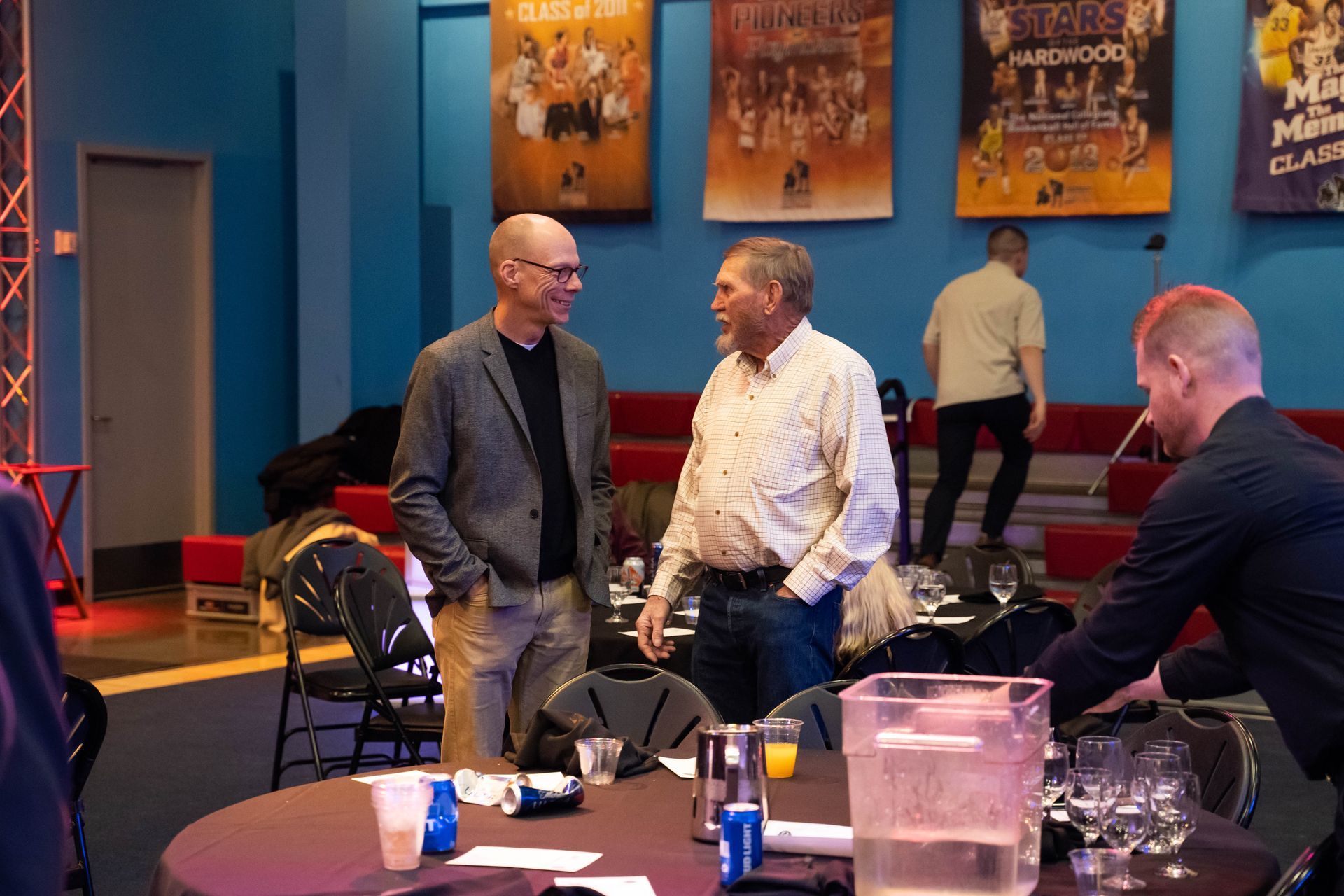 Two men are standing and talking at the ICL party.
