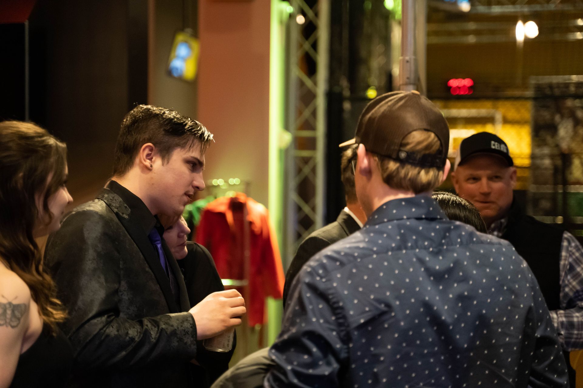 Two men are standing at the party and talking.
