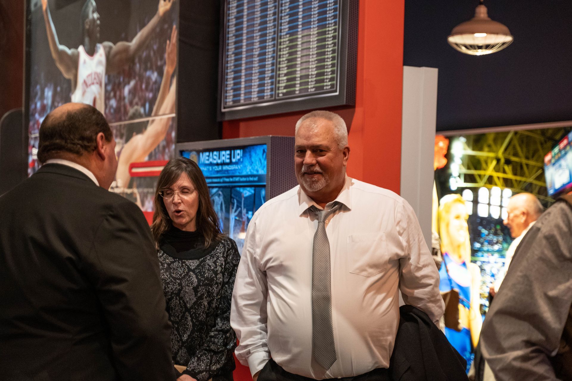 A few people are standing around talking at the 100 year anniversary party for ICL.