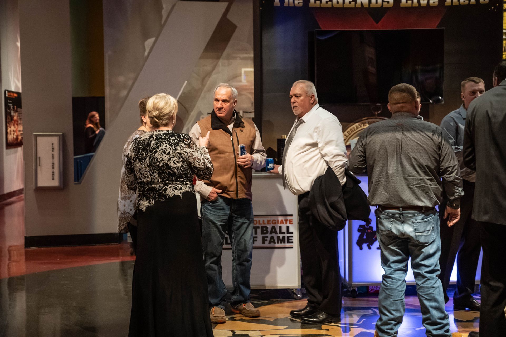 People are standing around drink beverages at the ICL party.