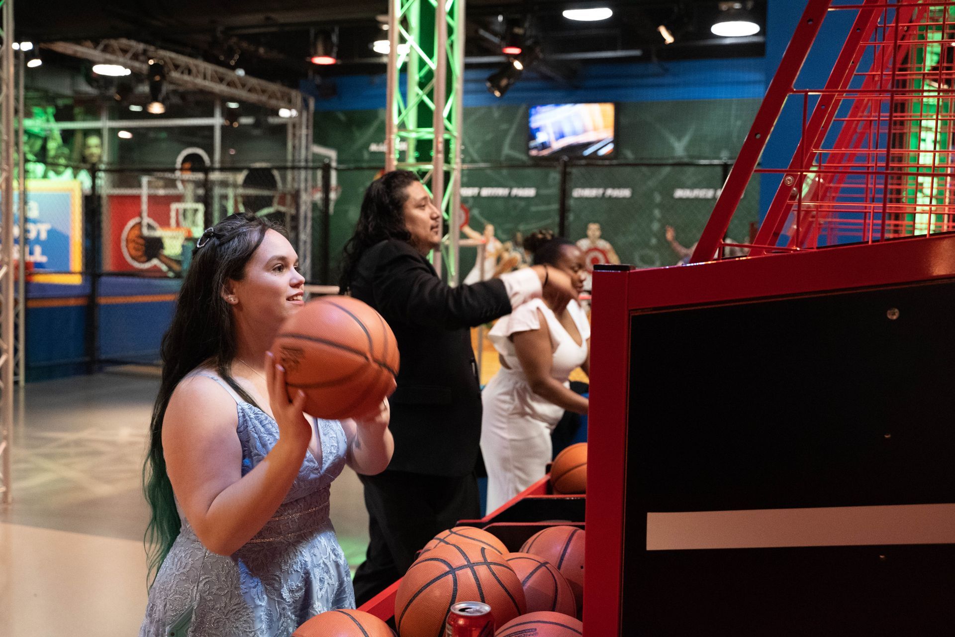 People are shooting basketball as a table game at ICL's 100 year anniversary party