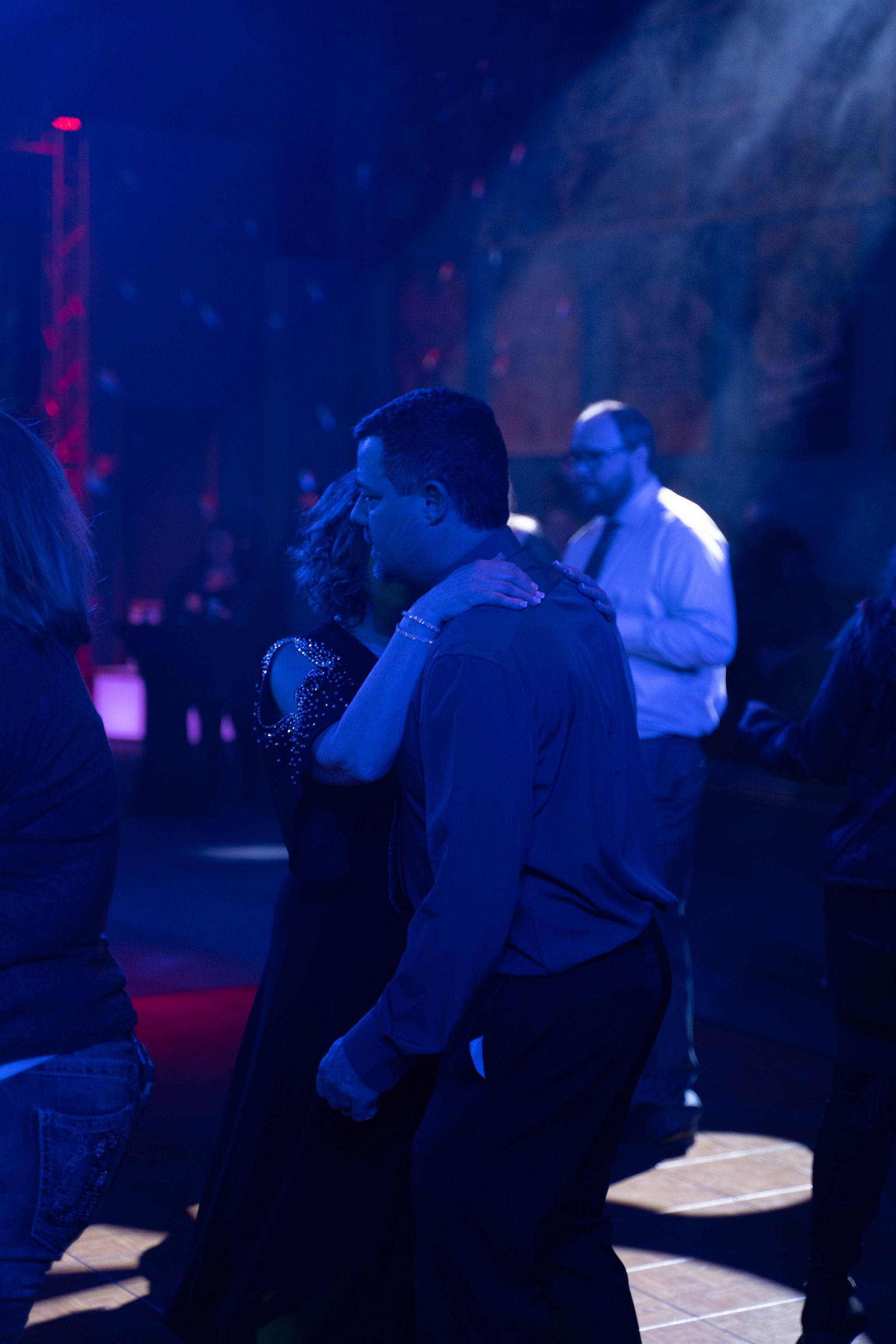  A couple hug and dance on the dance floor.