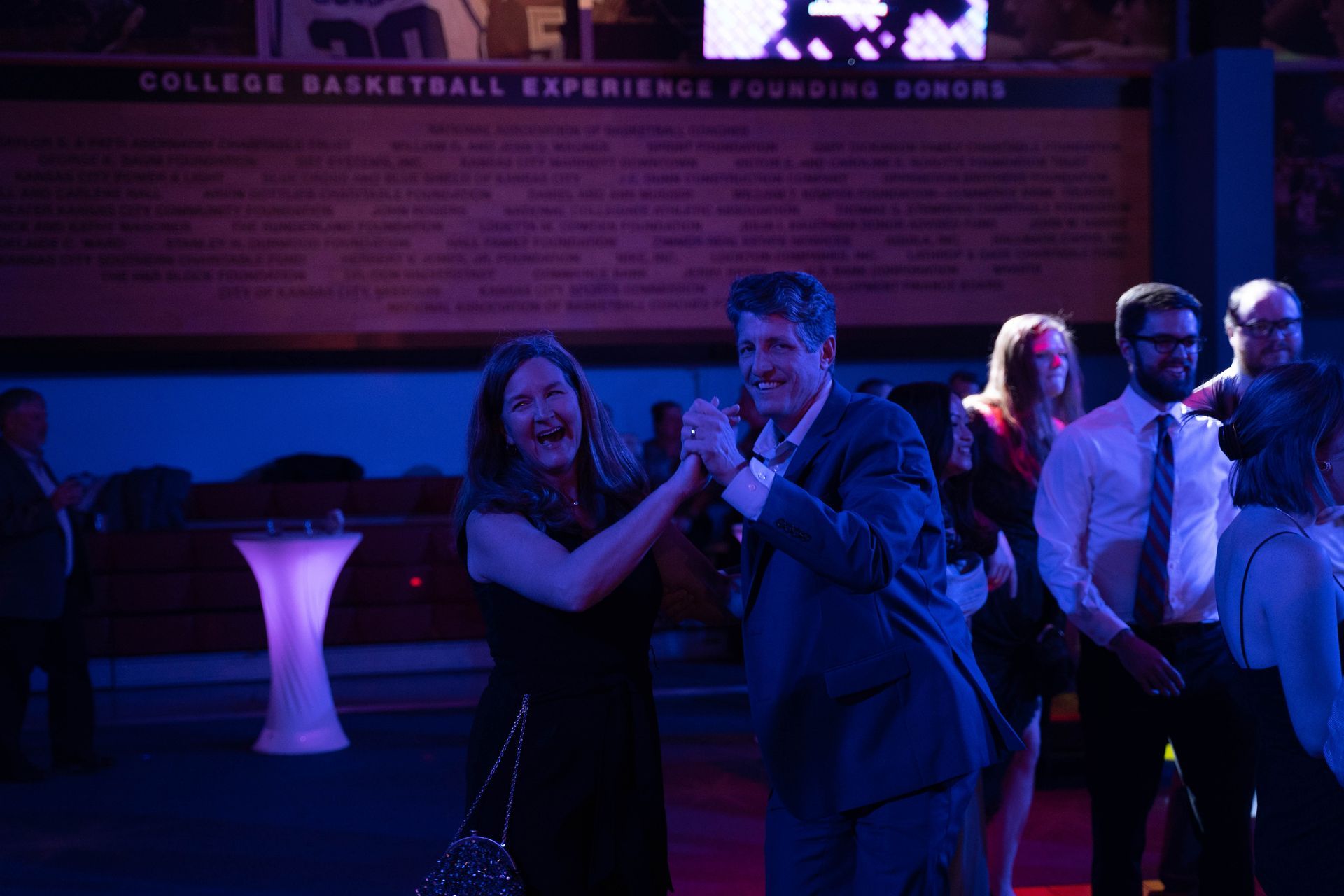A couple is laughing and dancing at the 100 year anniversary party for ICL