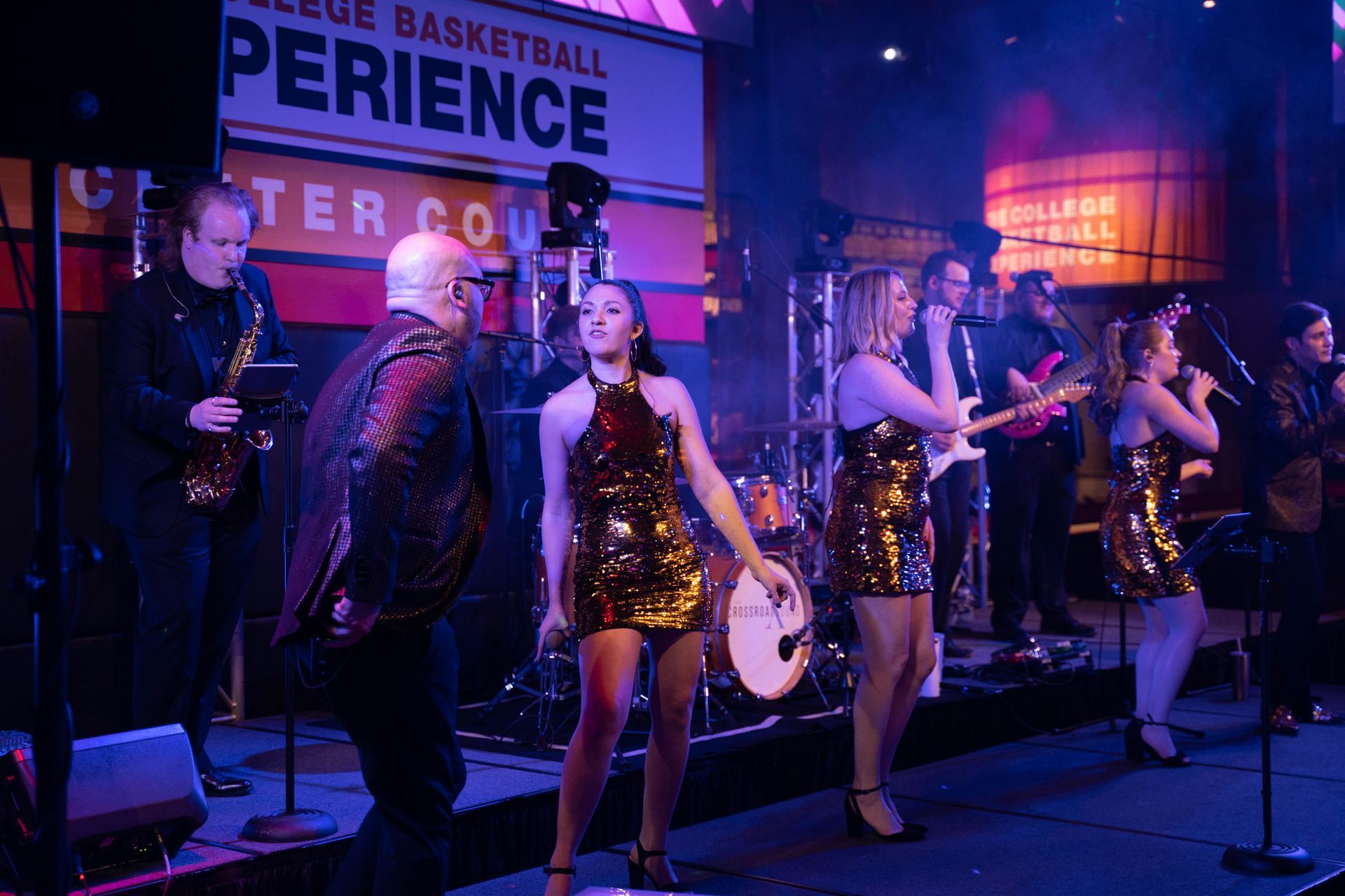 A woman in a gold sequence dress is performing for the crowd at the 100 year anniversary party forr ICL