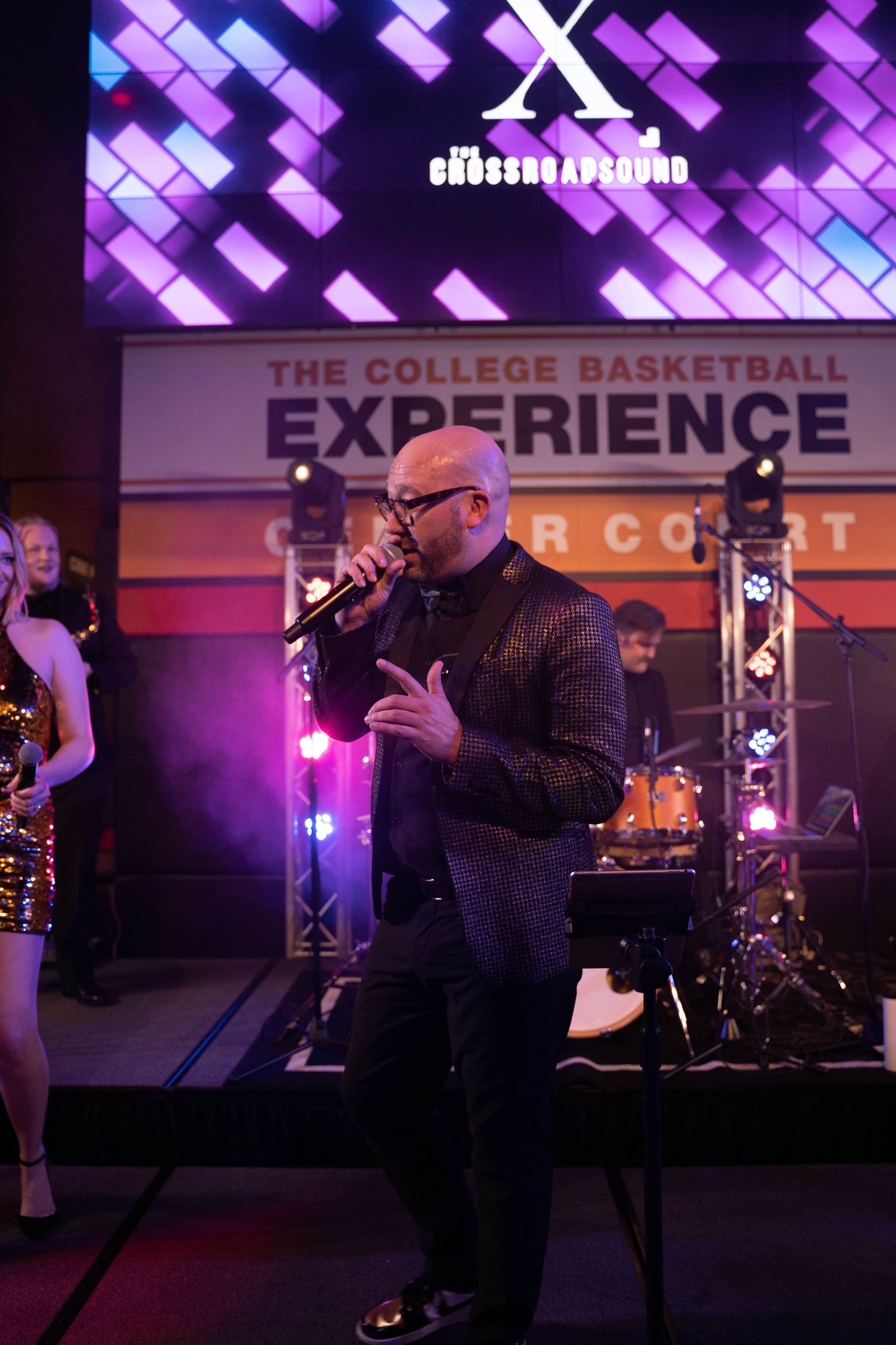 A man is holding a microphone and talking to the crowd.