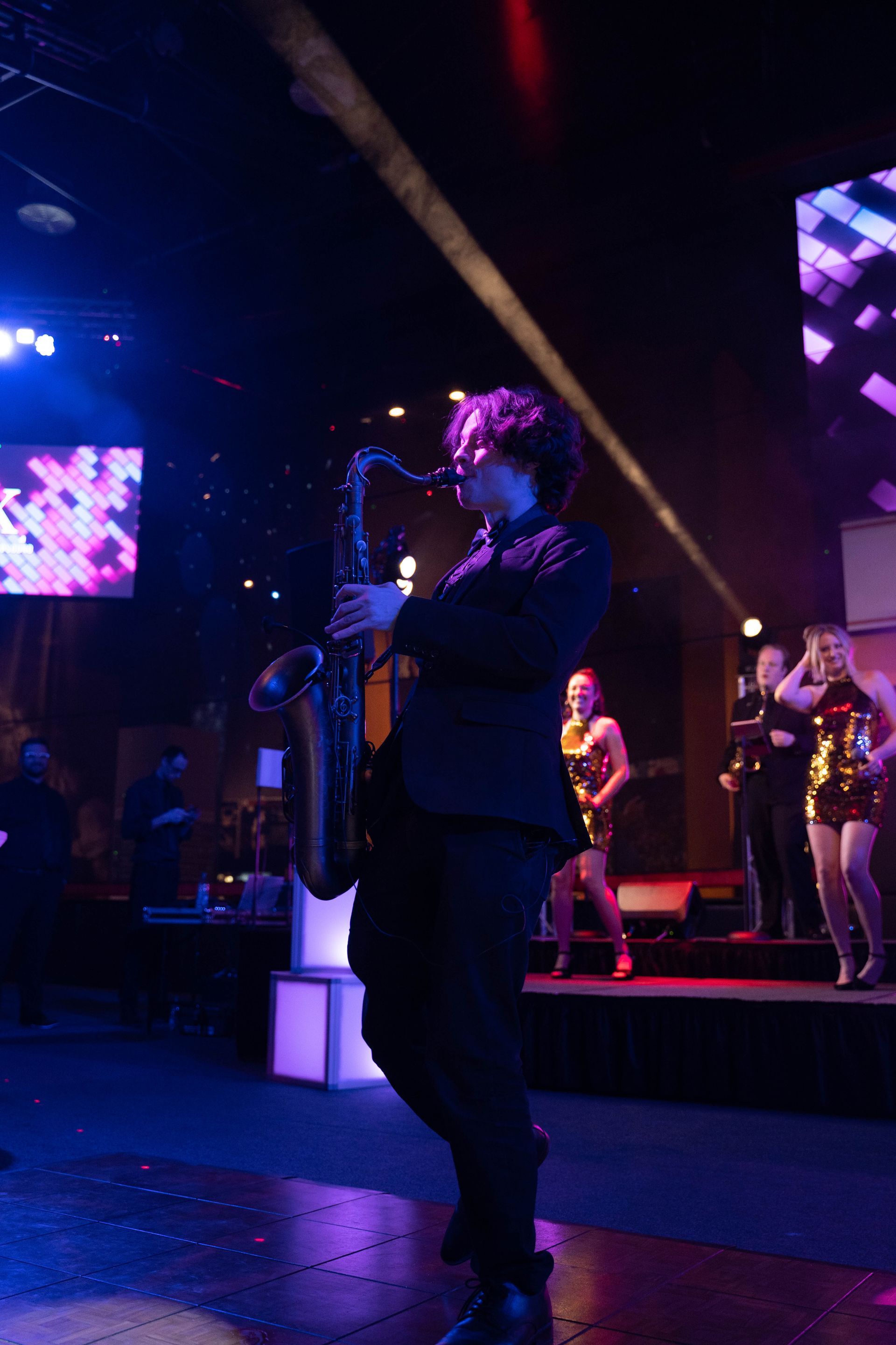A saxophone player is playing at the 100 year aniversary party for ICL.