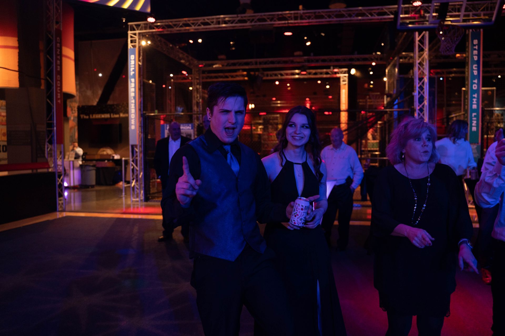 A man is standing on the dance floor and yelling something at the camera at the 100 year anniversary party
