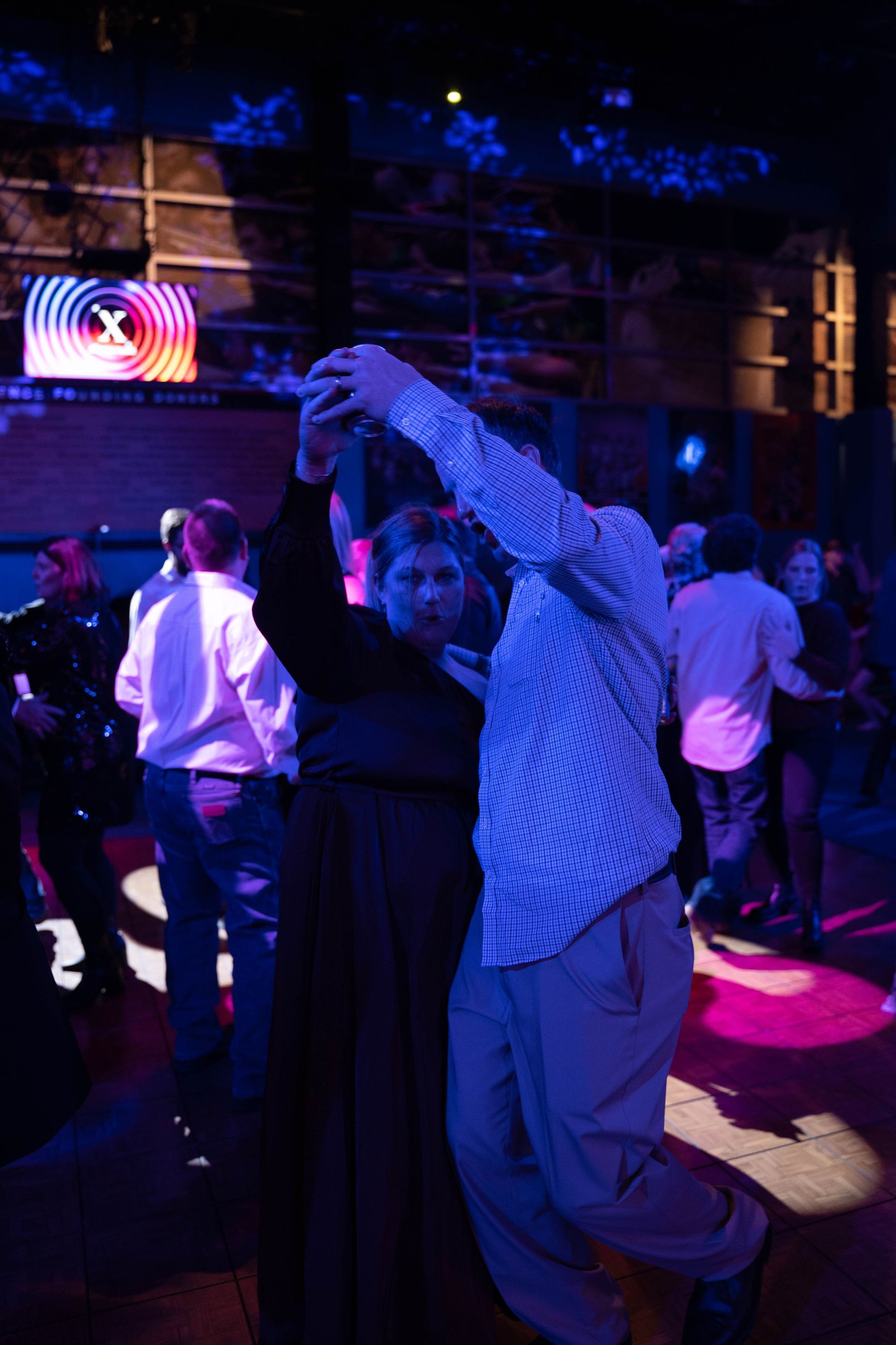 A man is spinning a woman on the dance floor of ICL's 100 year anniversary party