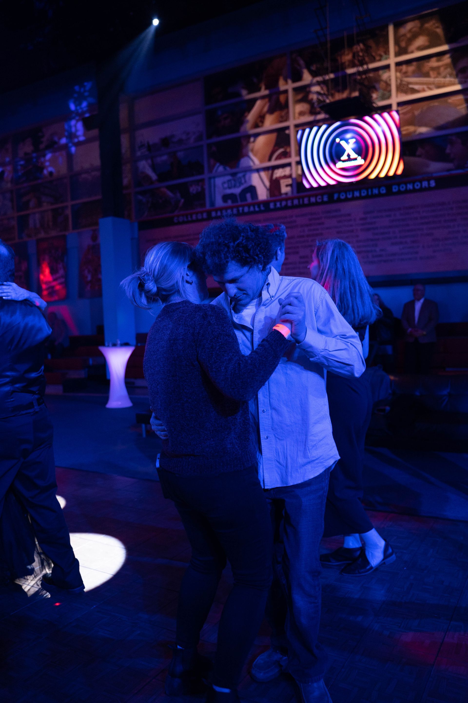 a couple is slow dancing at ICL's anniversary party